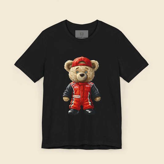 A teddy bear wearing a red karting suit with black accents and name patch "Champ", and a backwards worn red cap on a black unisex t-shirt