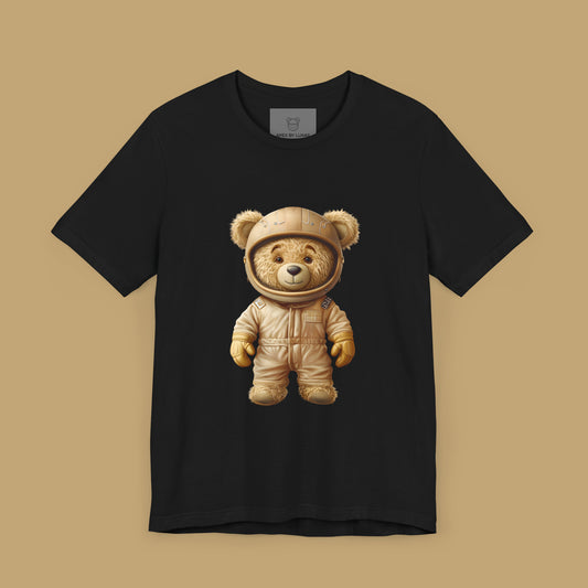 Light brown teddy bear wearing a beige retro karting racing suit and a helmet on a black unisex t-shirt