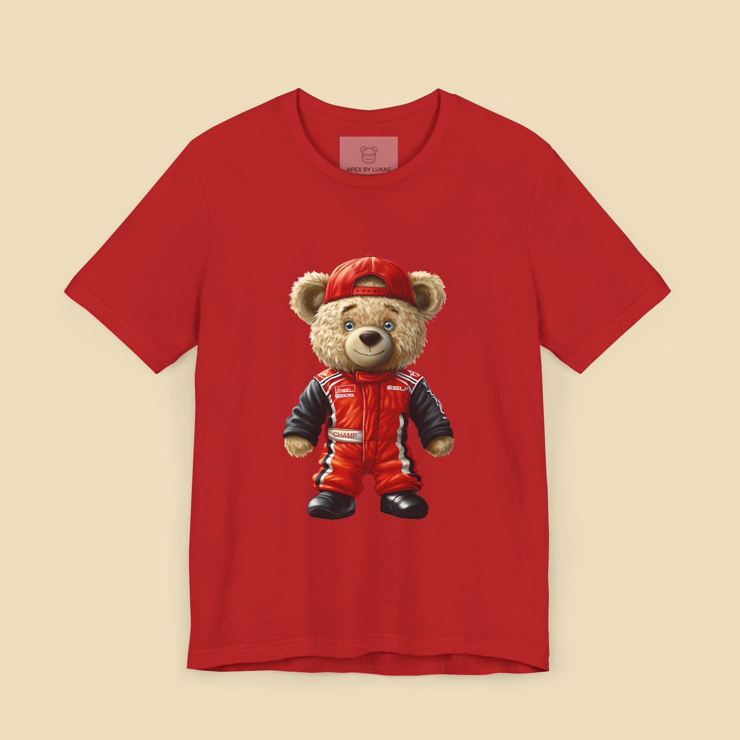 A teddy bear wearing a red karting suit with black accents and name patch "Champ", and a backwards worn red cap on a red unisex t-shirt