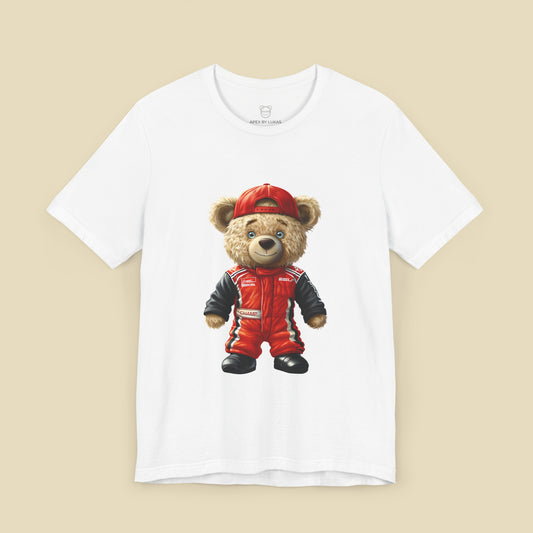 A teddy bear wearing a red karting suit with black accents and name patch "Champ", and a backwards worn red cap on a white unisex t-shirt