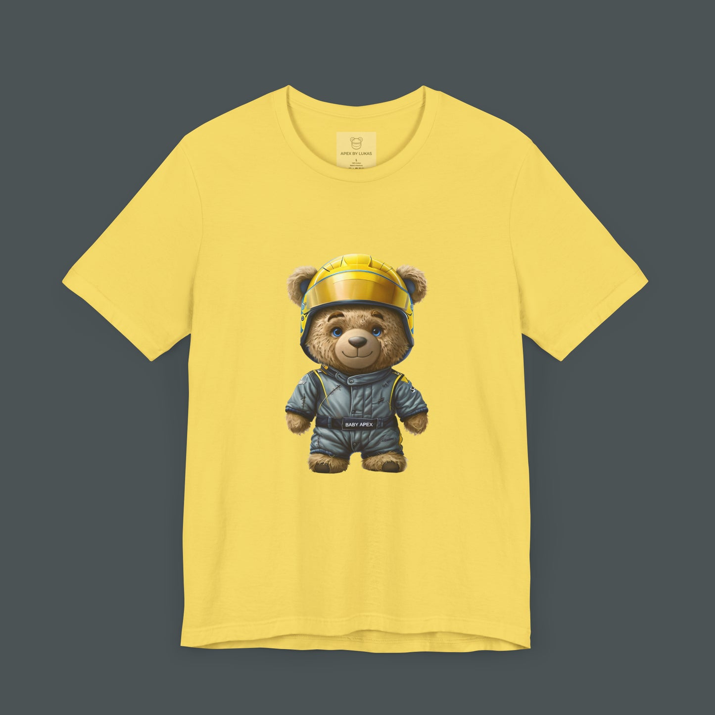 A rookie teddy bear wearing an oversized grey-blue karting racing suit and a yellow helmet on a yellow t-shirt