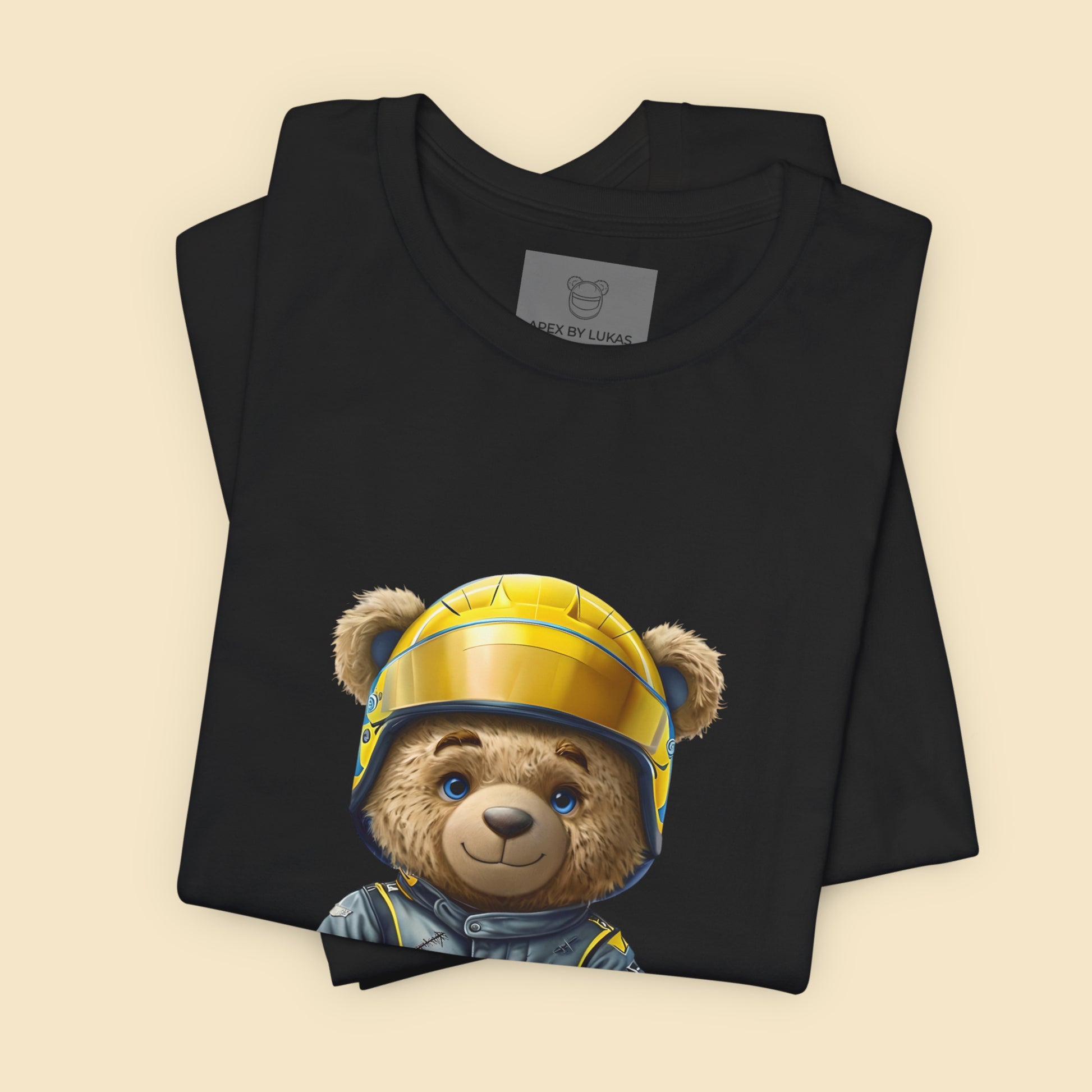 A rookie teddy bear wearing an oversized grey-blue karting racing suit and a yellow helmet on a black t-shirt