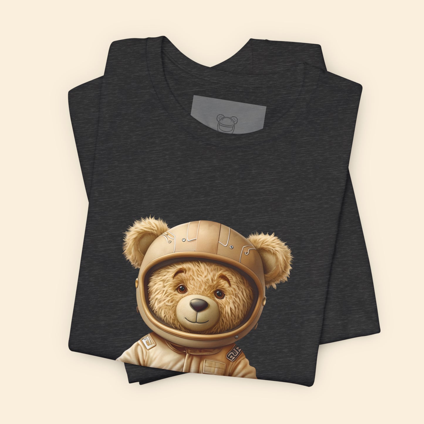 Light brown teddy bear wearing a beige retro karting racing suit and a helmet on a dark grey heather unisex t-shirt