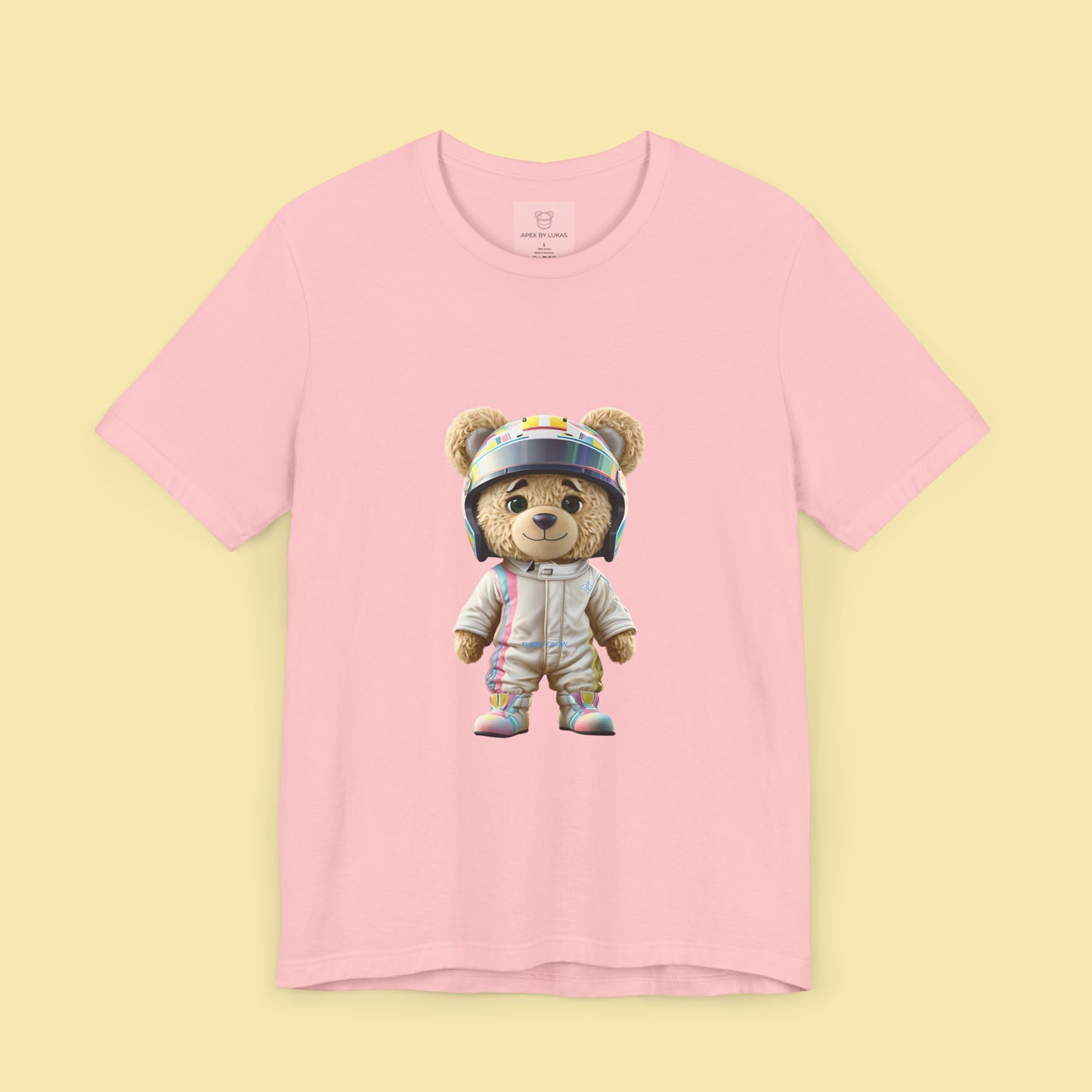 Teddy bear wearing a karting racing suit in beige color with light pink and blue lines on the side and a helmet on a pink t-shirt